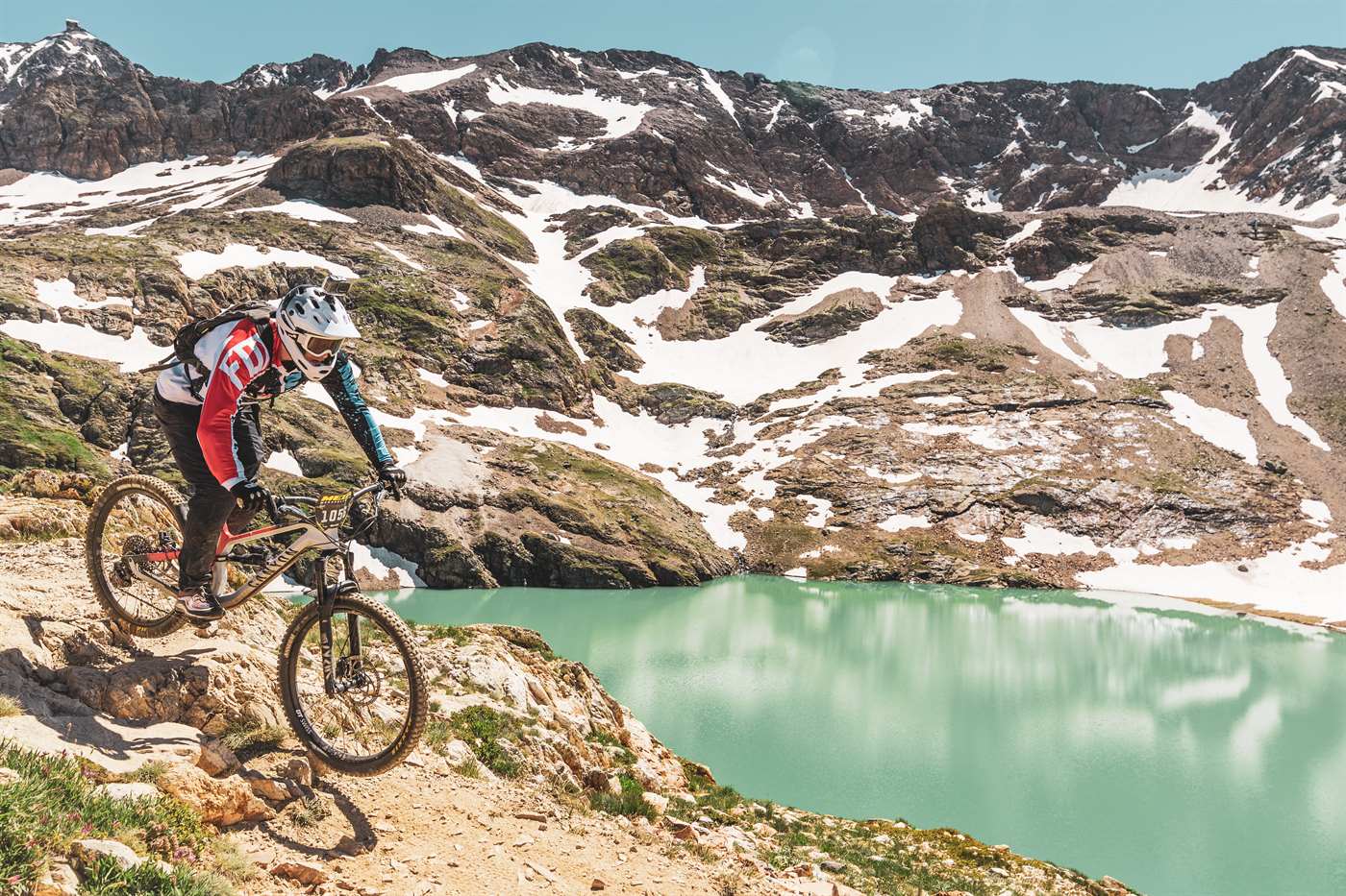 Louis en VTT au bord d'un lac de montagne, pendant la Mégavalanche à l'Alpe d'Huez